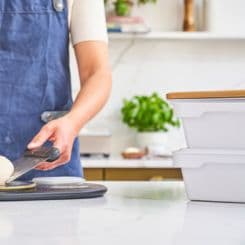 Woman placing pizza dough on plate