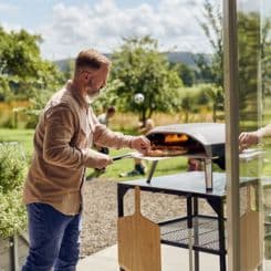 man cooking pizza using Ooni Large modular table