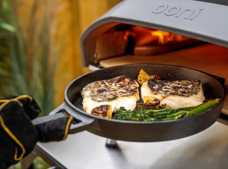  Fish going into oven in Ooni black grizzler pan