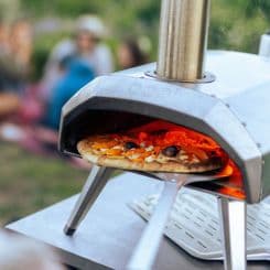 Ooni turning peel grabbing pizza from oven