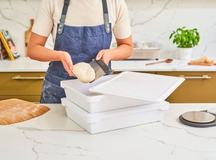 Woman cutting pizza dough