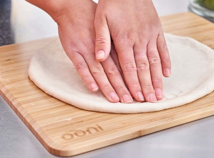 Flatening out pizza dough on Ooni prep lid