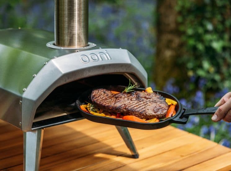 Meat in grizzler pan going into Ooni Oven