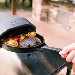 Taking meat out of oven using Ooni black grizzler pan