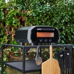 Ooni volt oven staged outside with accessories