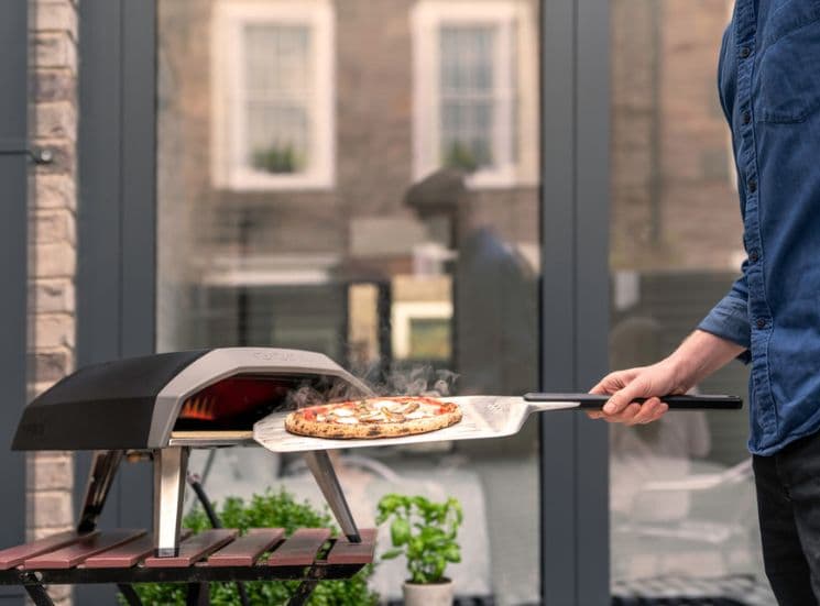 Pizza coming out of oven using Ooni 12'' perforated pan