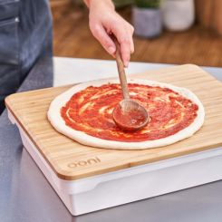 Adding pizza sauce on dough using Ooni prep lid