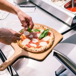 Garnishing pizza on Ooni 14'' bamboo peel