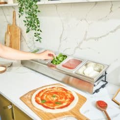 Grabbing pizza toppings from Ooni pizza station