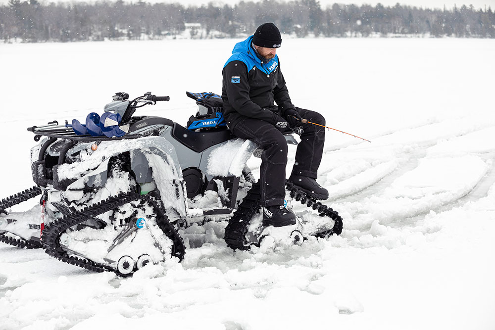 ATV with track kit and man fishing on ice