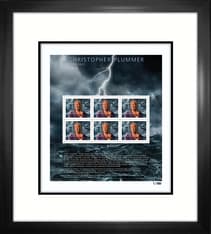 Art in a black frame. Depicts a collage of 6 stamps of Christopher Plummer, his autograph, and dark scenes from his starring films. 