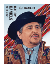 Stamp with &quot;Harry Daniels&quot; and a photo of him in a broad-brimmed black hat, in front of a Métis sash under a blue sky. 