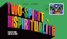 Front of envelope shows “Two-Spirit” in rainbow block letters against a green background. Stamp top right corner with sacred fire cancel mark.