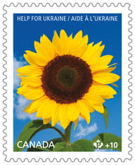 Stamp with &quot;Help for Ukraine&quot; text and a bright yellow sunflower with a black centre and green leaves, atop a blue sky background. 