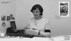 Cover, with a black and white image of Simonne Monet-Chartrand, her stamp, and a cancel mark. She is sitting at her desk, sorting papers.