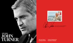 Pli Premier Jour avec le texte « John Turner » et « 1929-2020 », son timbre, son autographe et son portrait en noir et blanc, sur fond rouge et noir. 