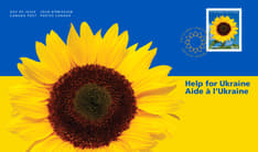 Pli Premier Jour orné du texte « Aide à l’Ukraine », du timbre de la collection et d’un tournesol jaune avec centre noir, sur un fond bleu et jaune. 