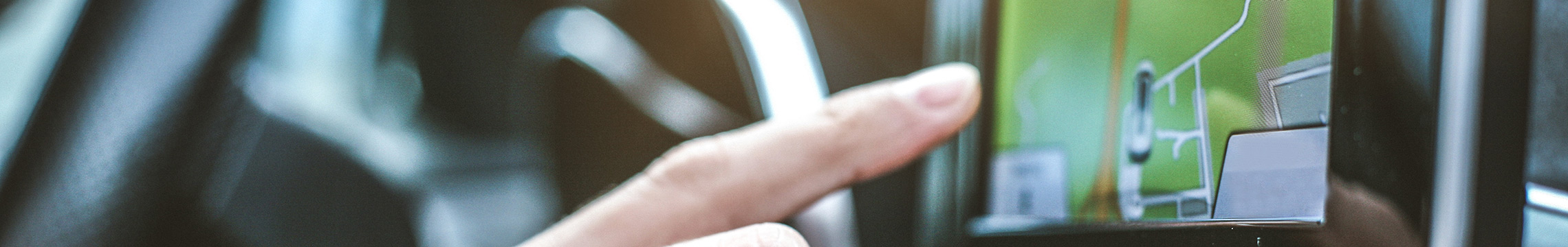 Man operating digital GPS unit via touchscreen while in car