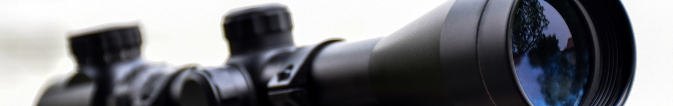 Close up of a black rifle scope mounted to a rifle