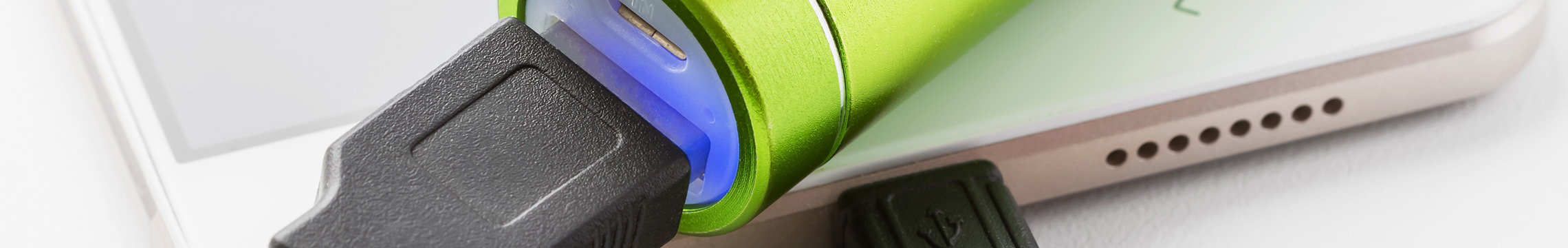 iPhone connected to a green portable charging bank via USB cord