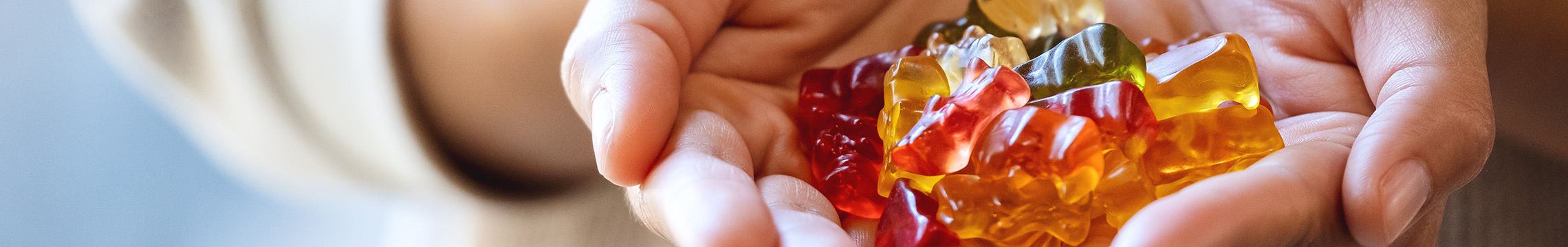 Hands cupped, holding assorted gummy bear candies
