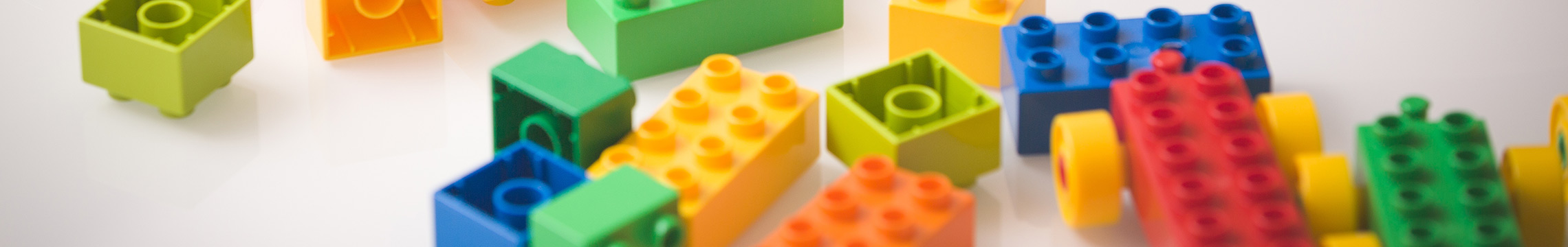 Multi-colored plastic building blocks scattered across a table