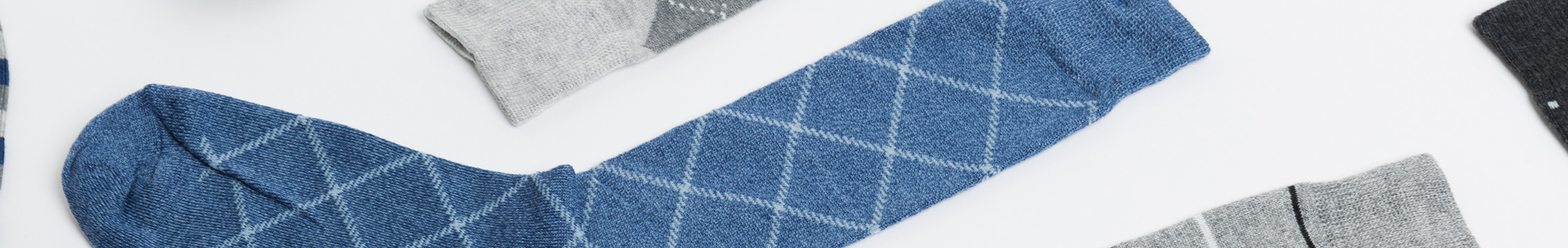 Men's dress socks scattered across a white background