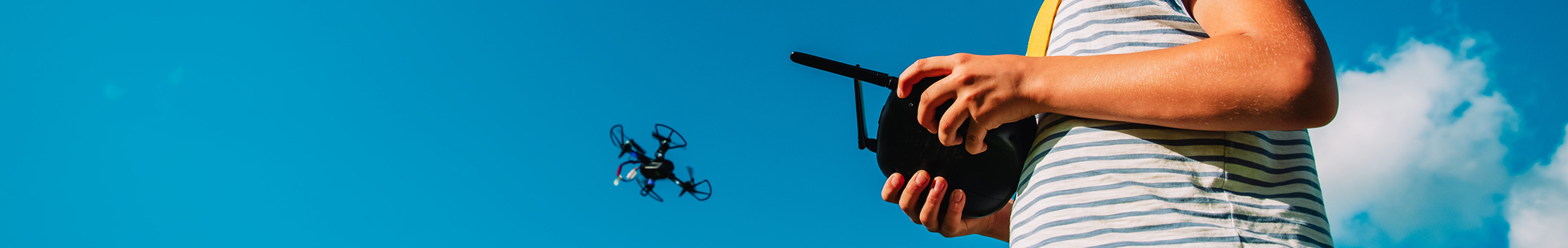 Kid playing with toy drone outside while wearing VR goggles