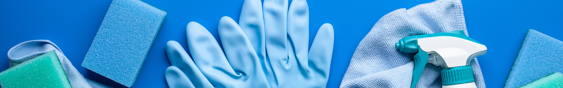 Cleaning chemicals, sponges, towels, and rubber gloves against a bright blue background