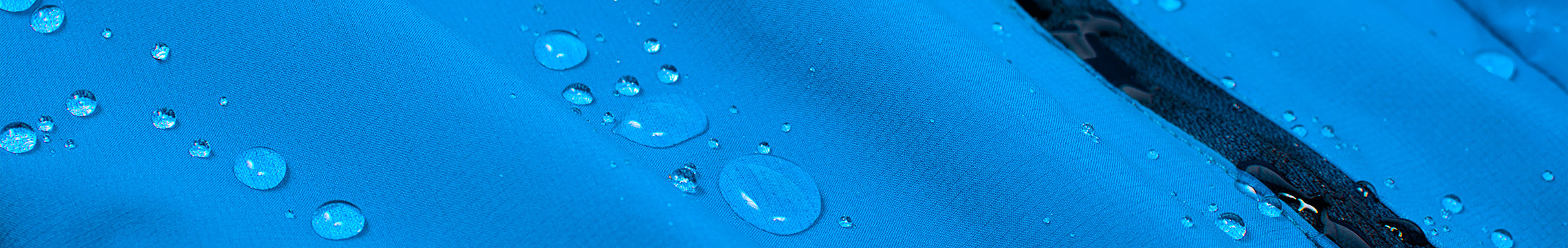 Close up on blue rain coat with beads of water running down