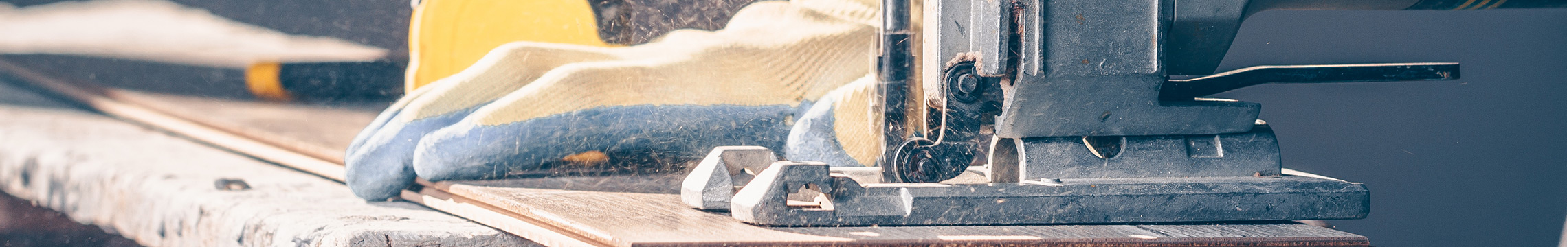 Handyman cutting a piece of flooring with an electrical jigsaw