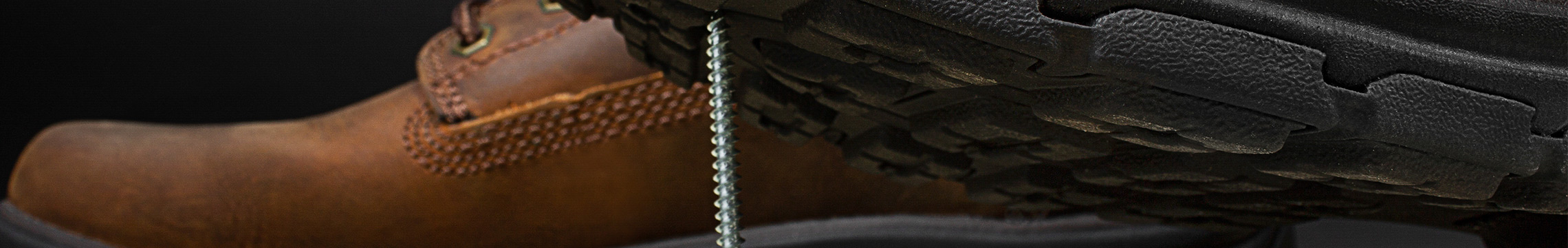 Brown men's work boots resting on screws