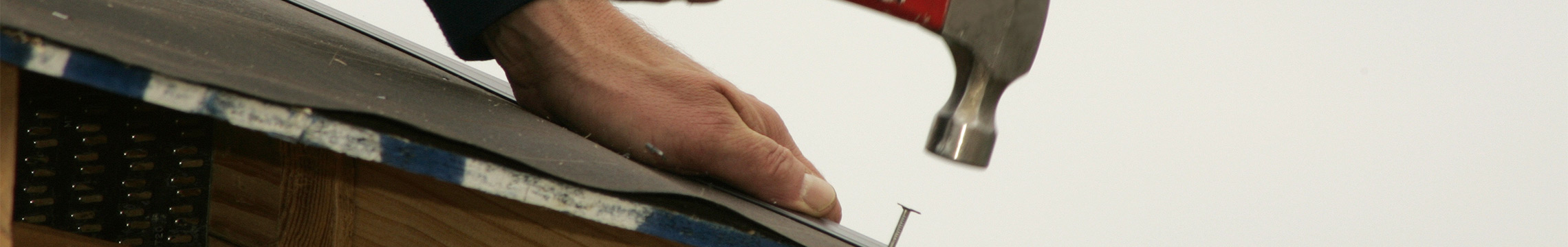 Hammer striking  a roofing nail