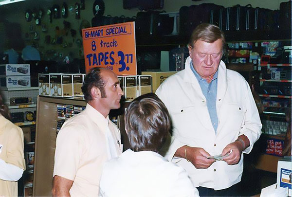 Film actor John Wayne visiting a Bi-Mart store