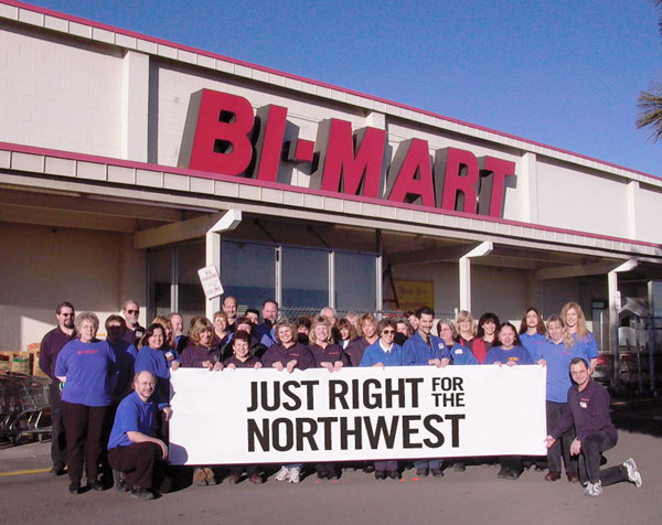 Bi-Mart Employees outside store with banner that says Just Right for the Northwest
